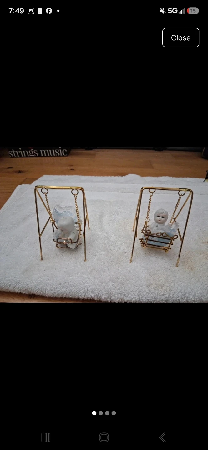 Pair of porcelain baby figurines on gold tone swings