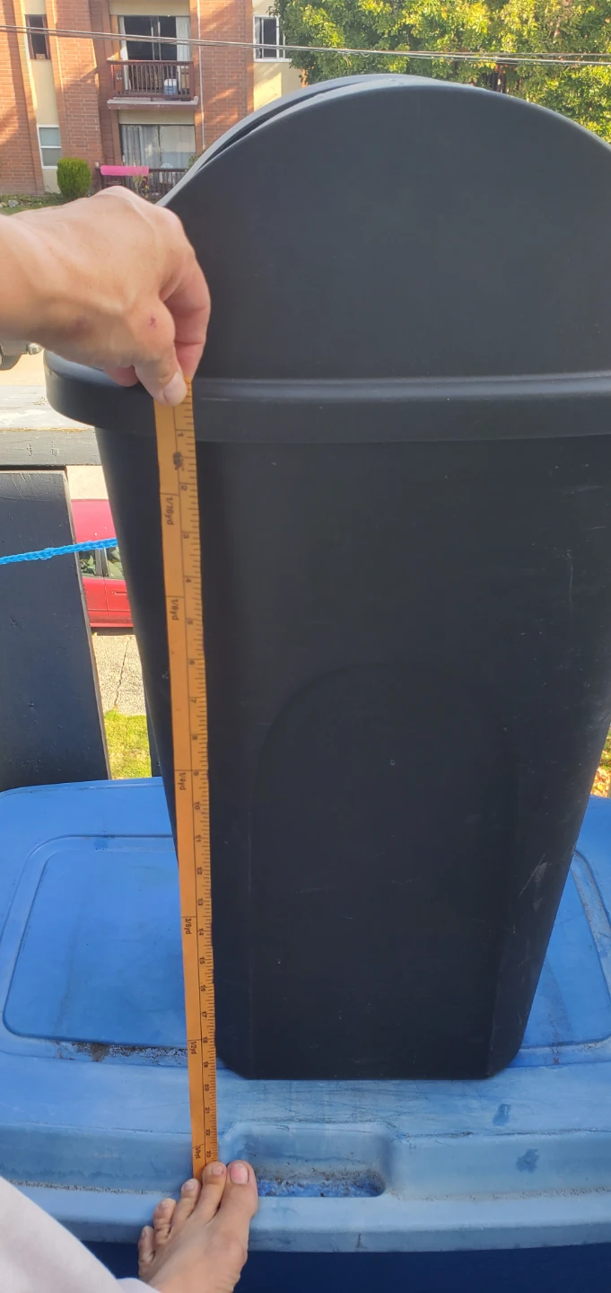 Black swing-top waste bin