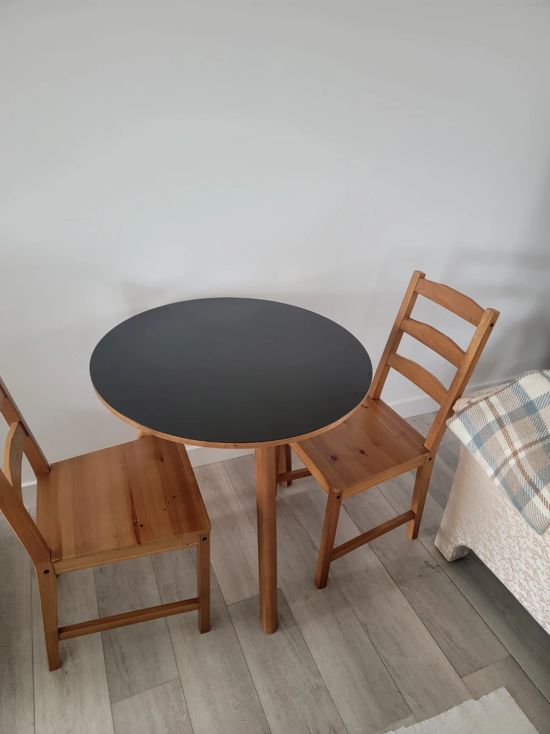 Round Black Table with Two Wooden Chairs