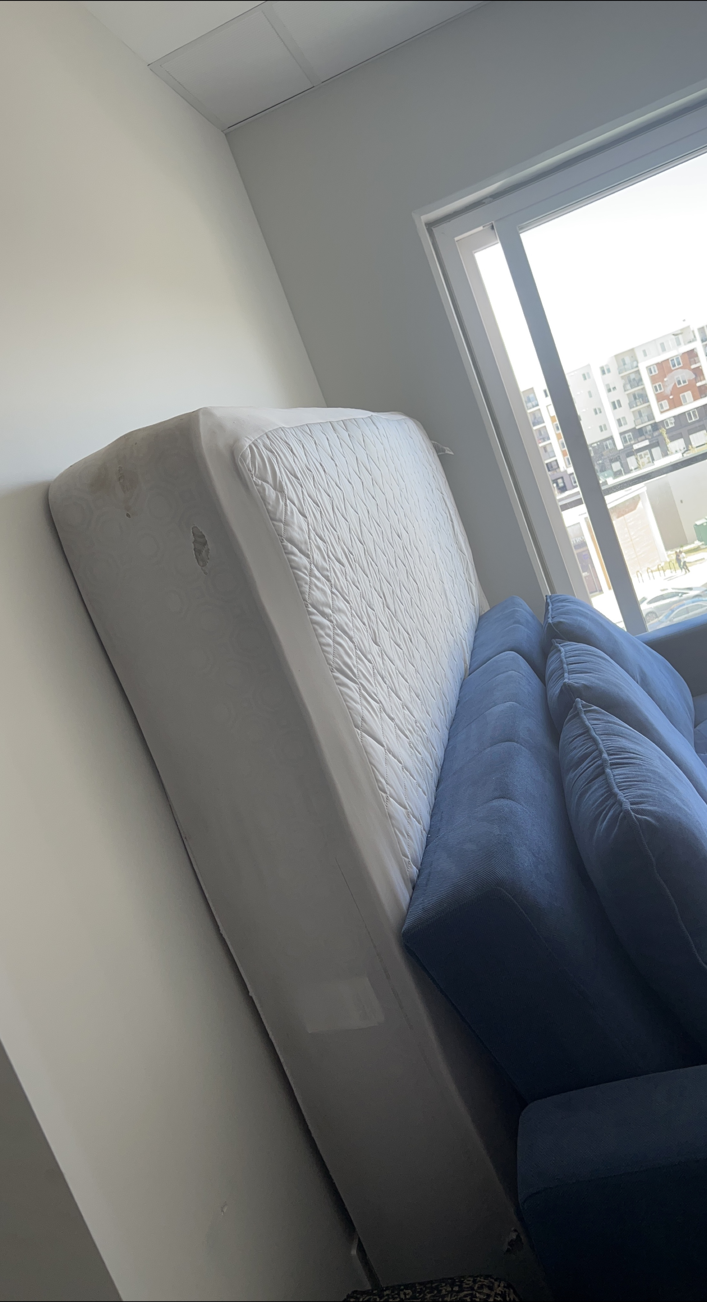 Used Mattress and Blue Sofa