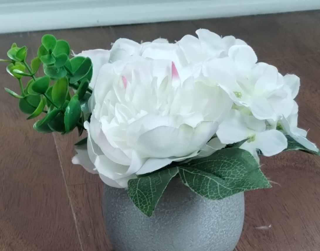 Artificial flowers in gray plaster pot