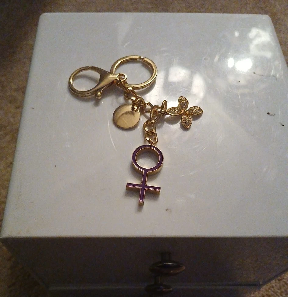 Gold-tone keychain with female symbol charm