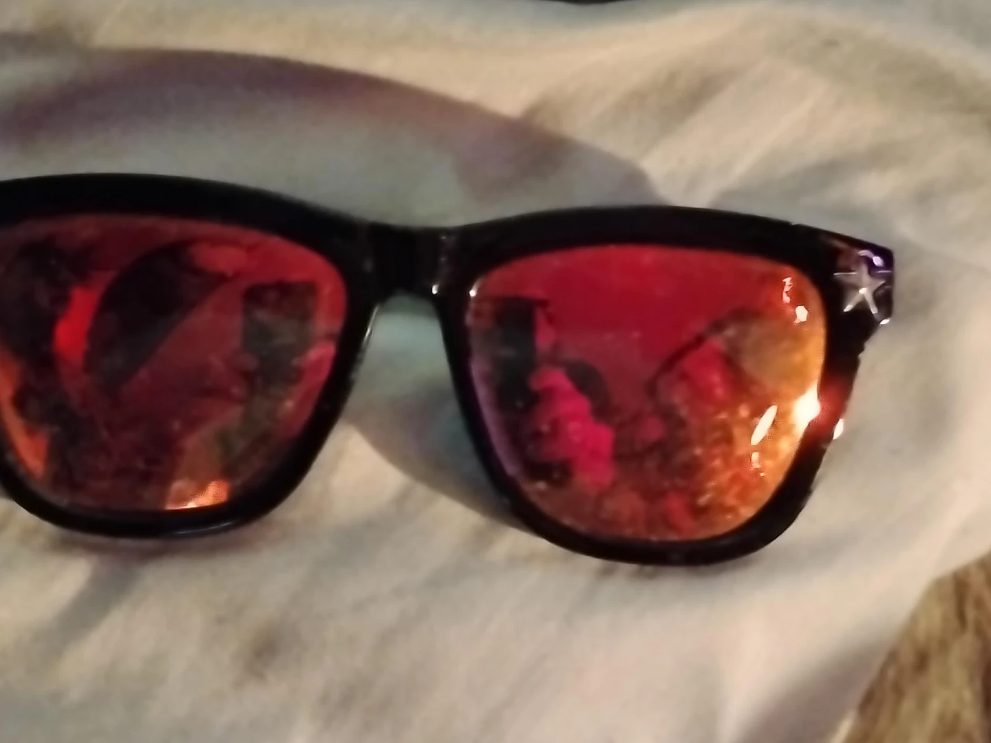 Black sunglasses with star details and red mirrored lenses