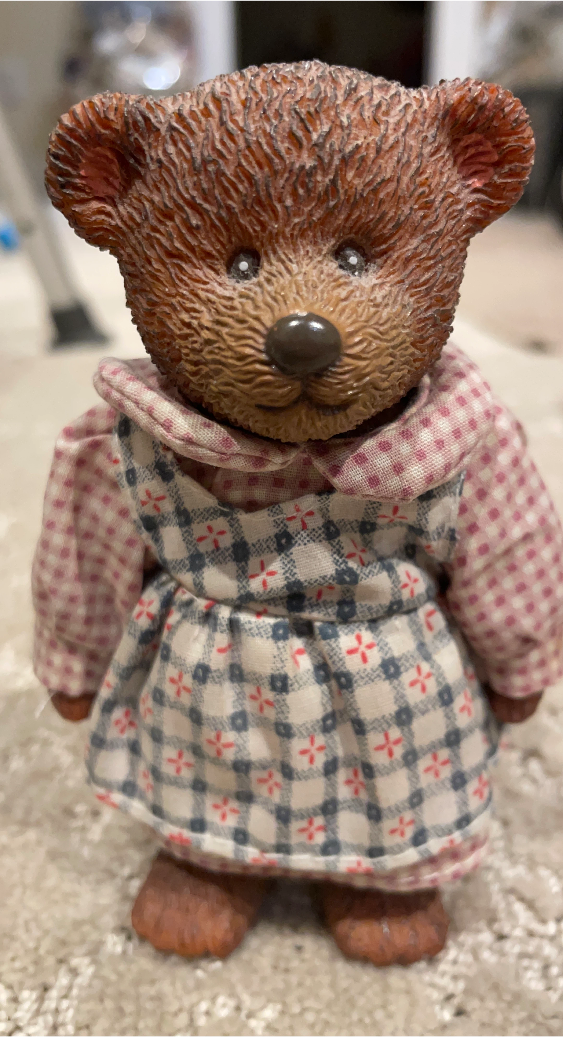 Brown teddy bear figurine with plaid dress