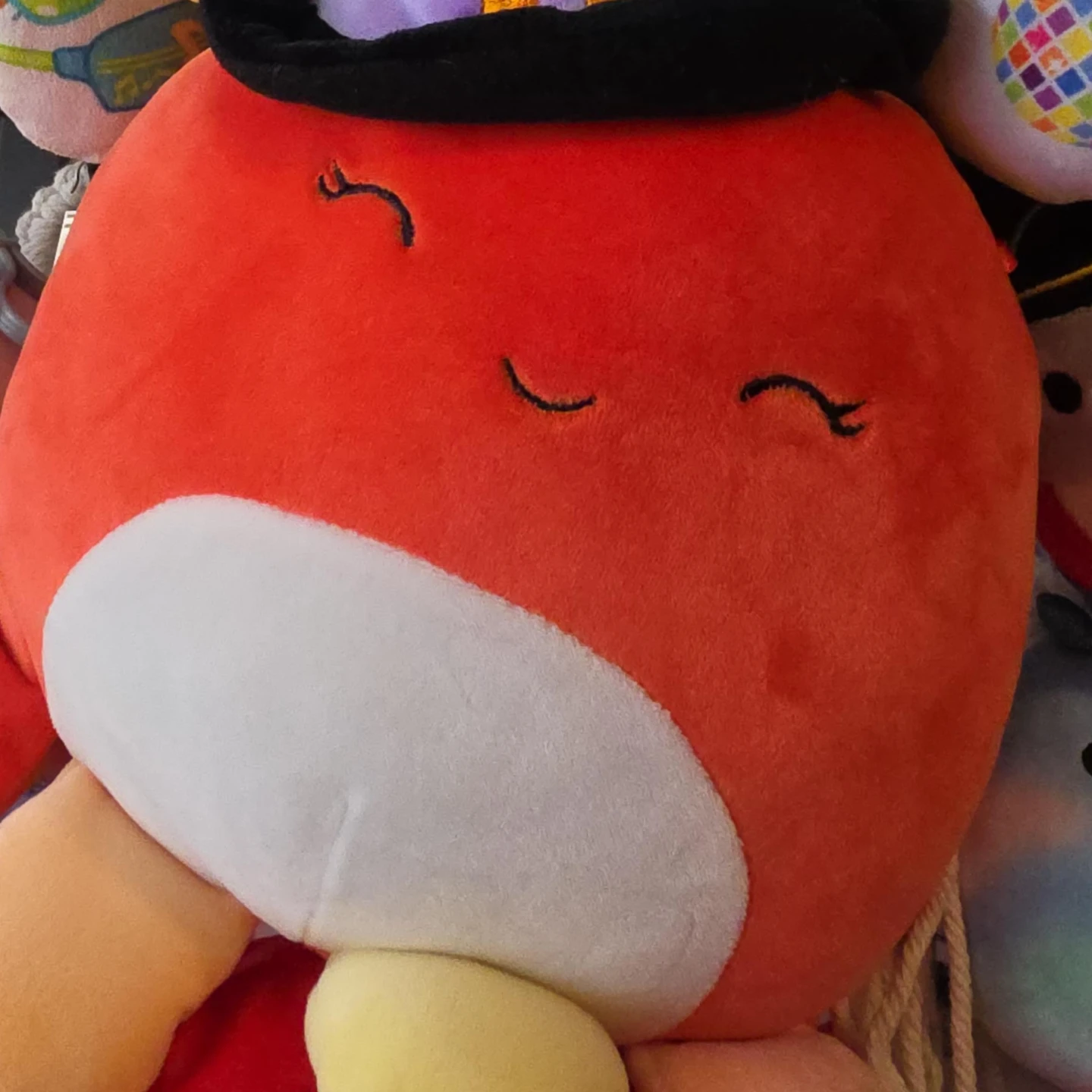 Orange plush toy with black hat