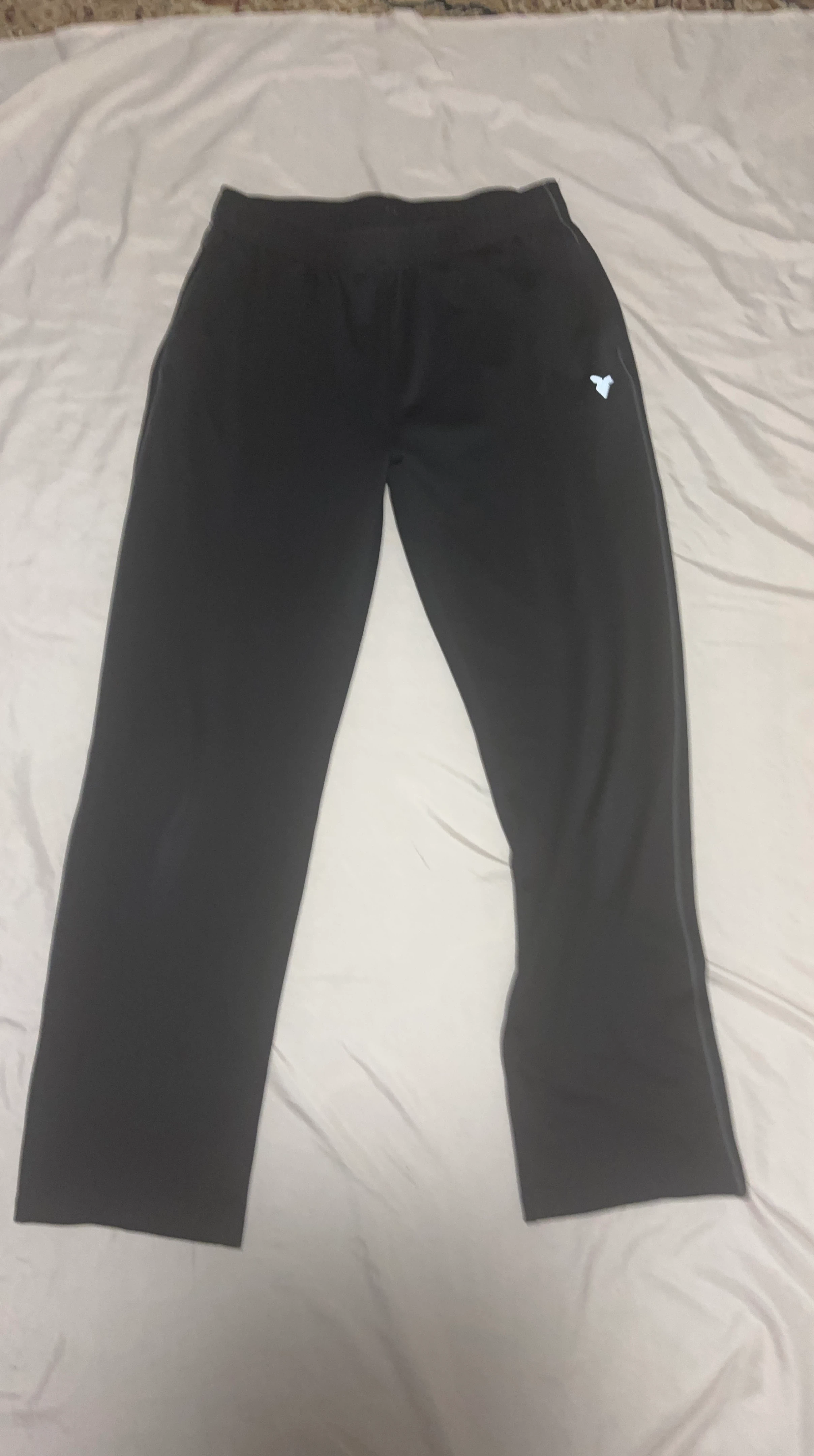 Black athletic pants with reflective logo