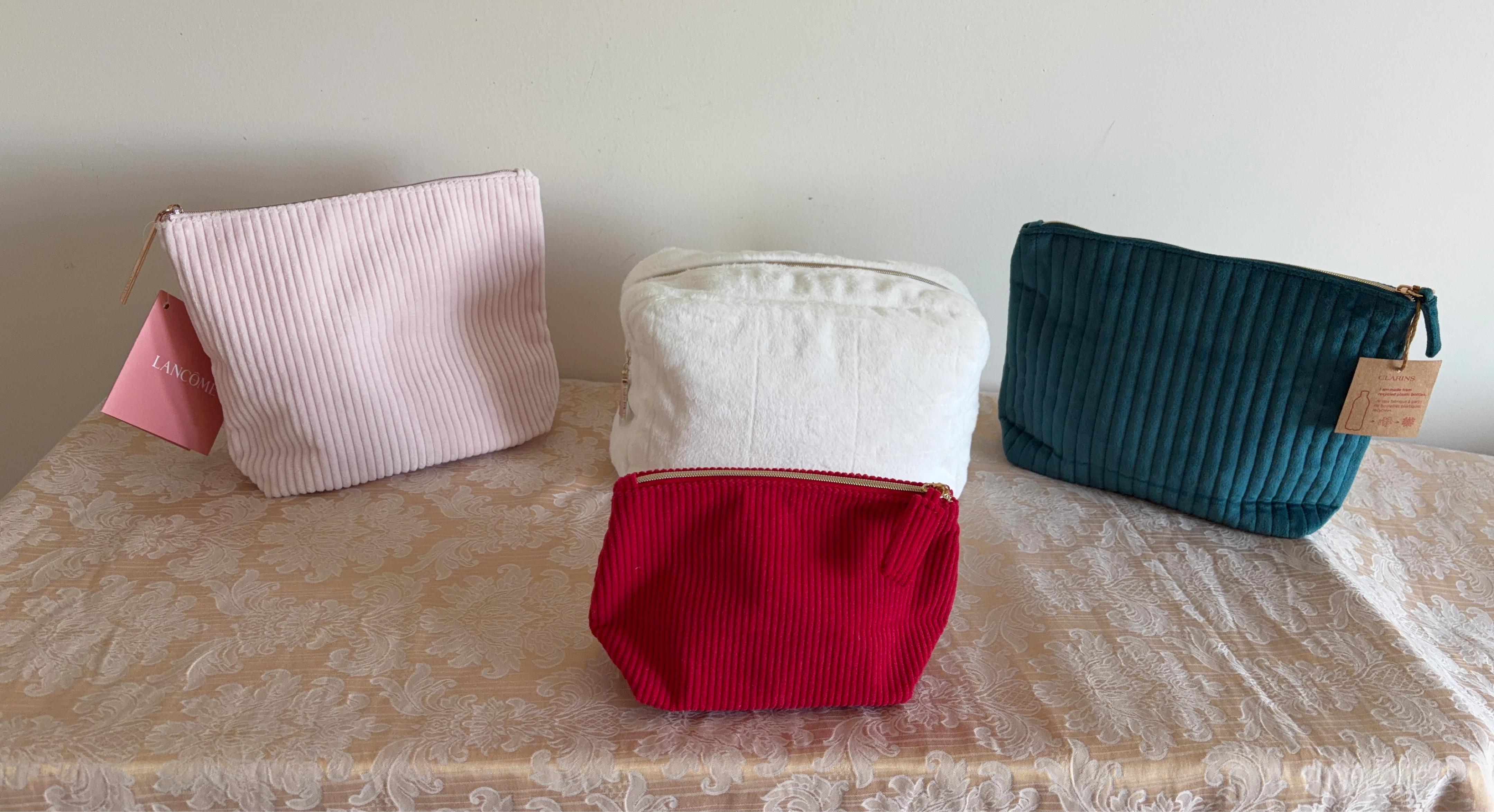 Four Cosmetic Bags: Lancôme, Clarins, and White Plush