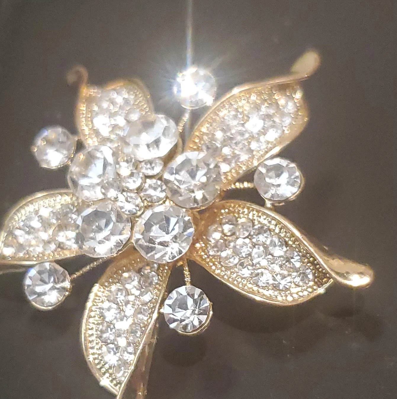 Gold tone floral brooch with clear crystals