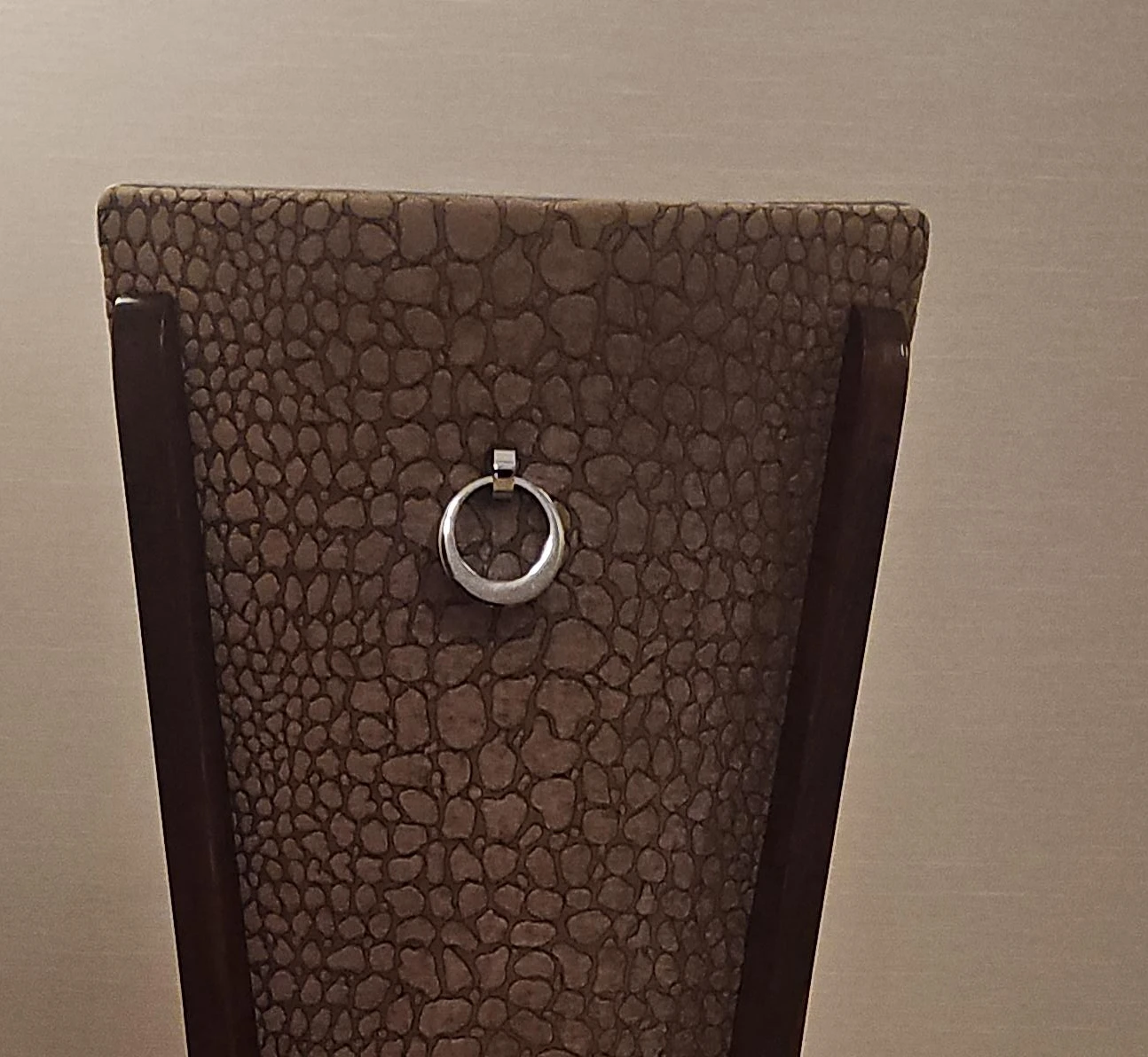 Dining chair with decorative metal ring  back accents.