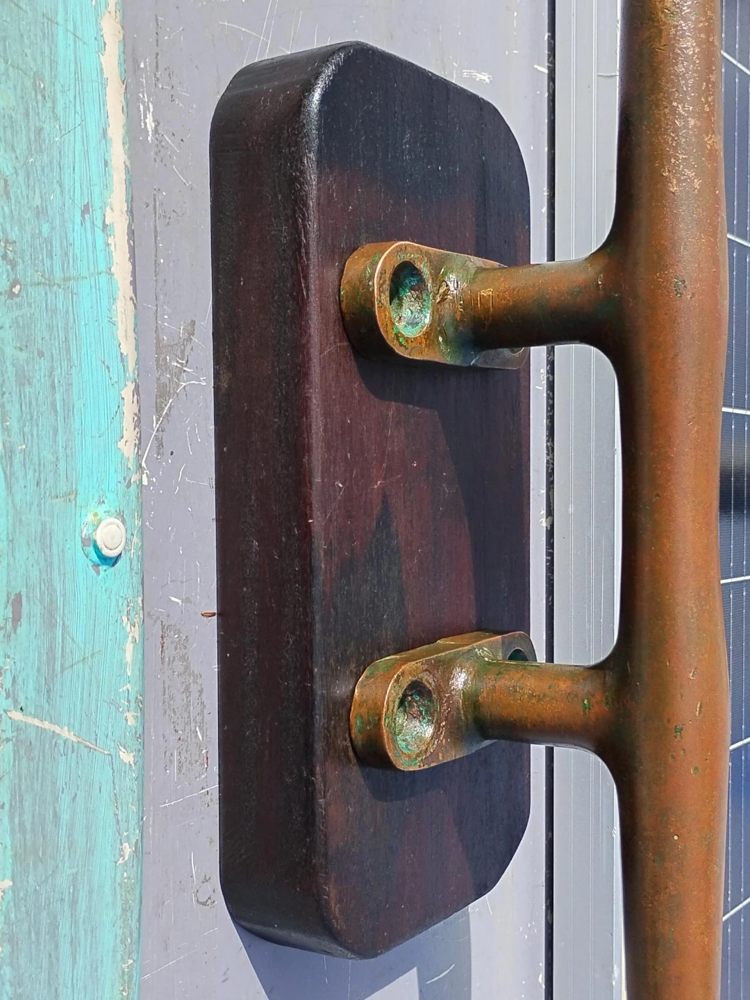 Large bronze ship cleat on hardwood base plate