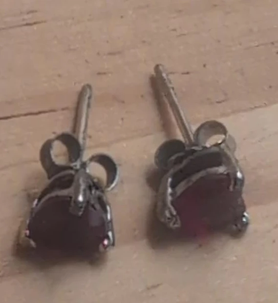 Silver tone stud earrings with ruby-coloured stones