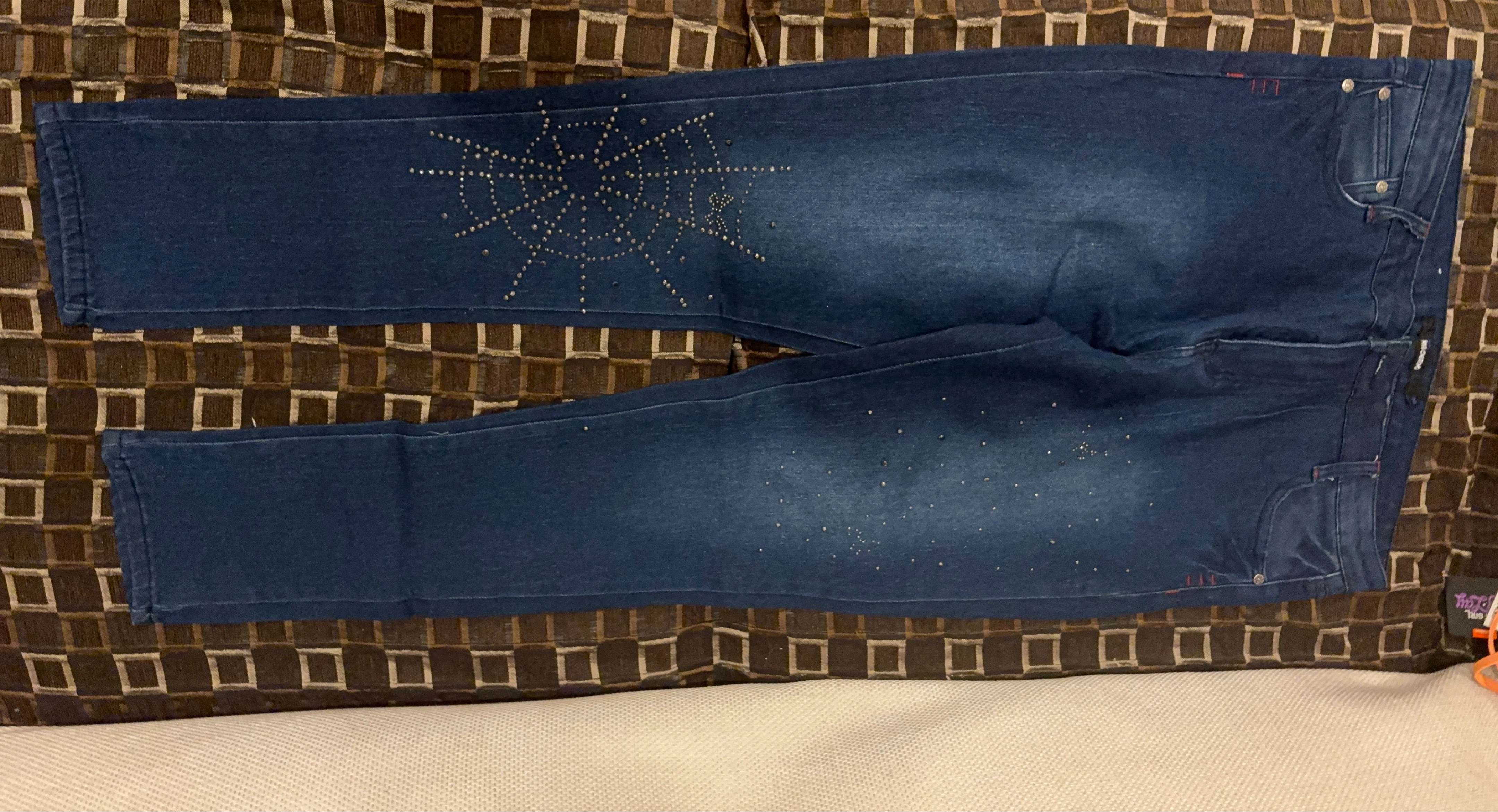 Blue jeans with spider web rhinestone detail