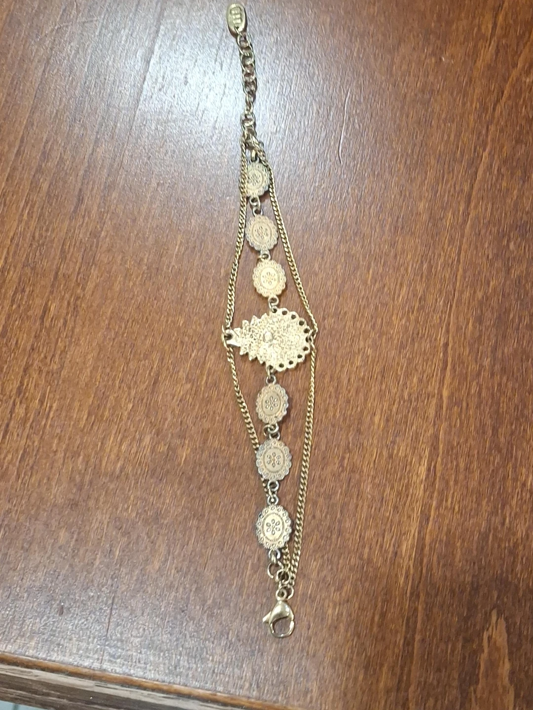 Gold tone layered bracelet with floral medallions