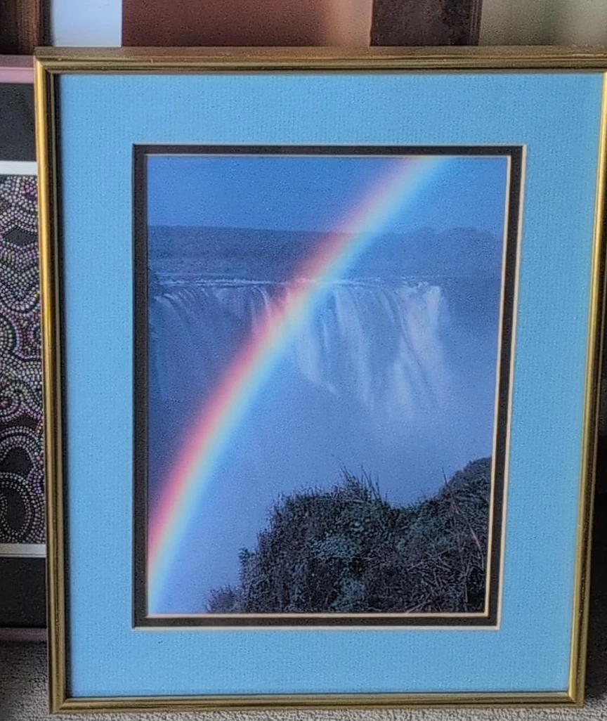 Framed Print of a Rainbow over a Waterfall