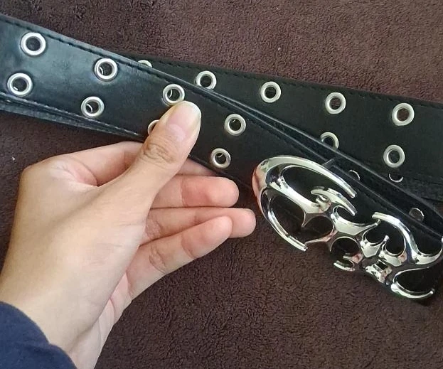 Black studded belt with silver skull buckle