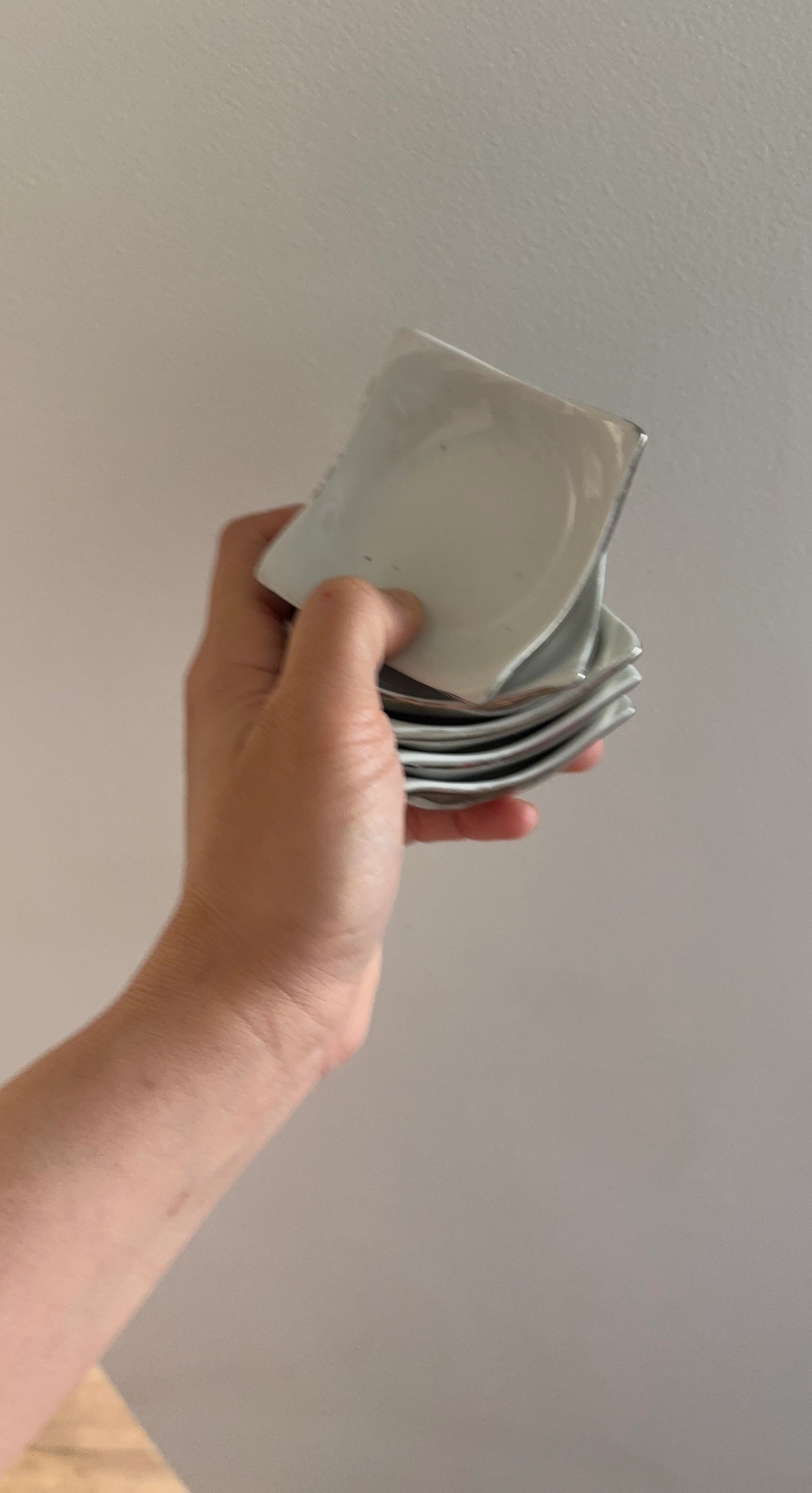 Stack of 5 small square white plates