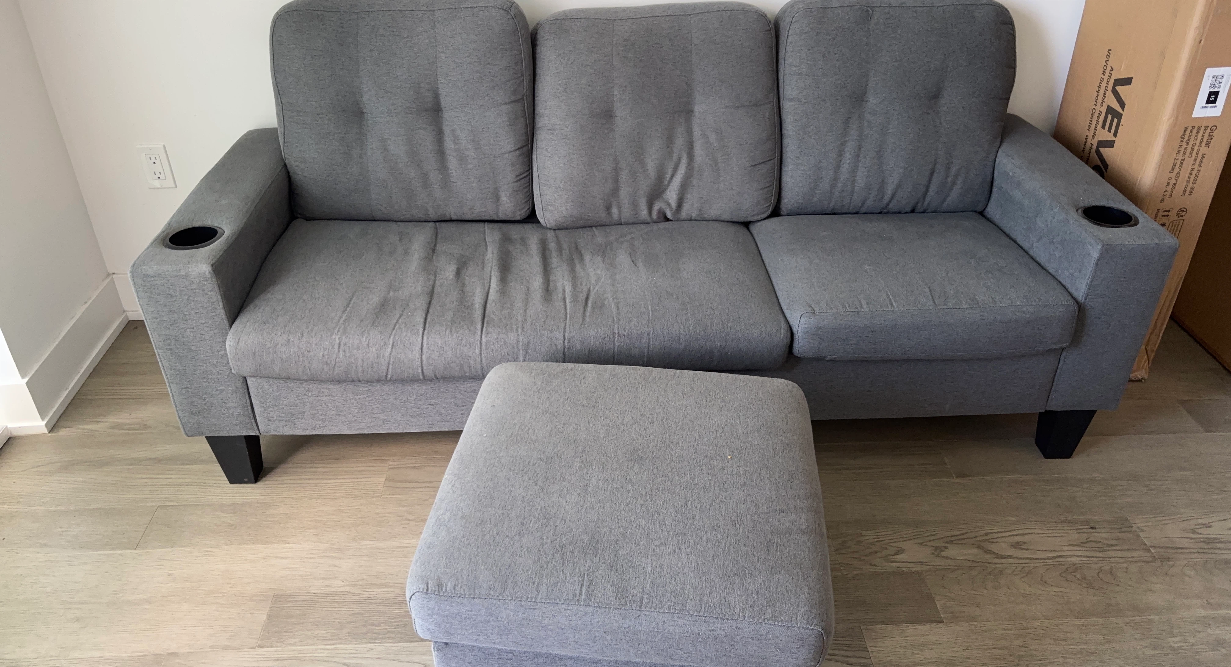 Grey fabric sofa with ottoman and cup holders