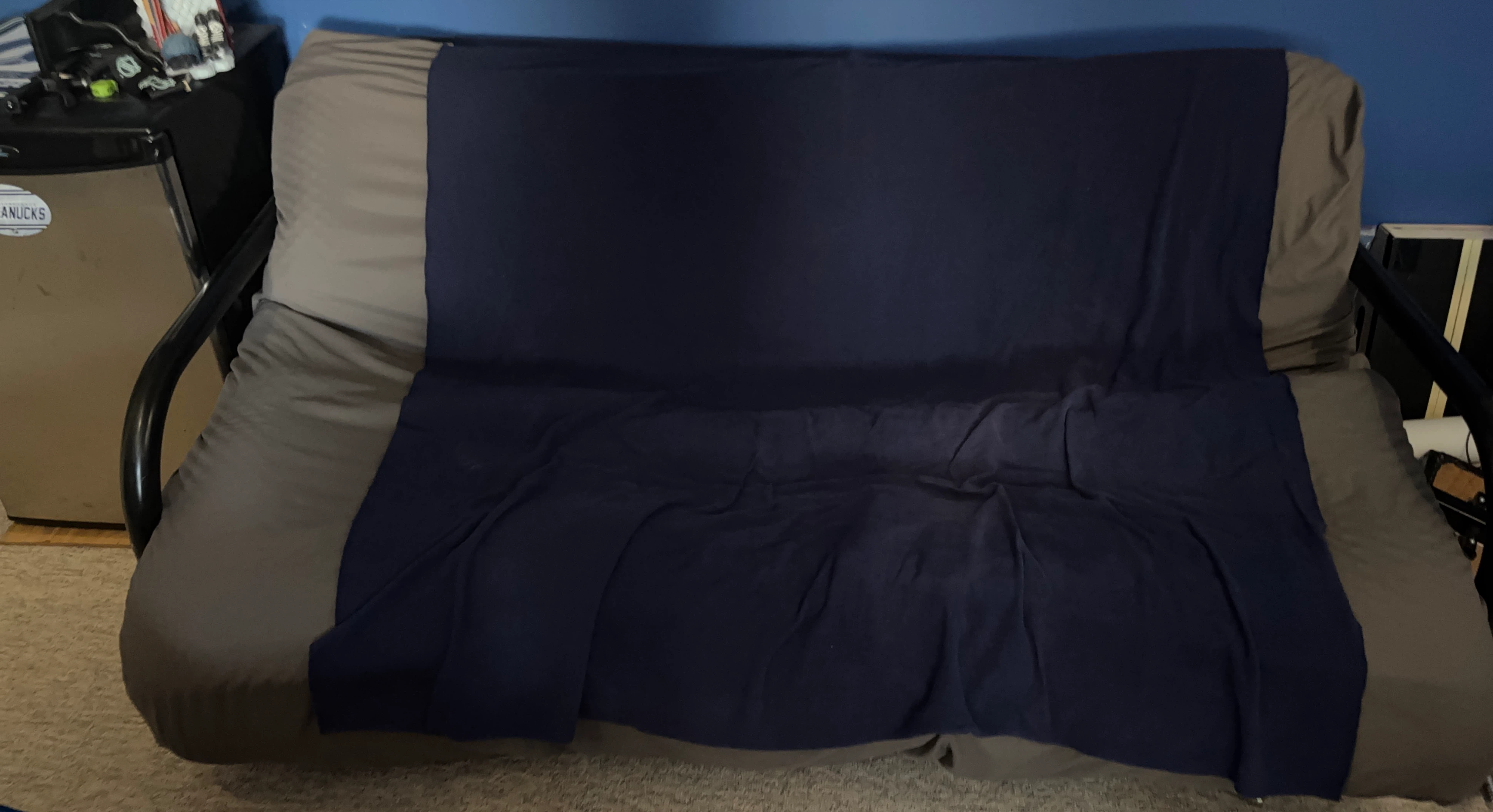 Futon Couch with Navy Blue Blanket