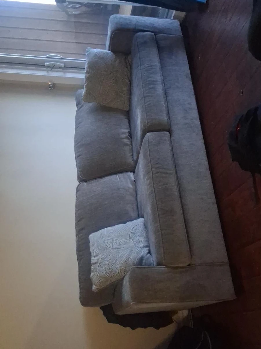 Grey fabric couch with two decorative pillows