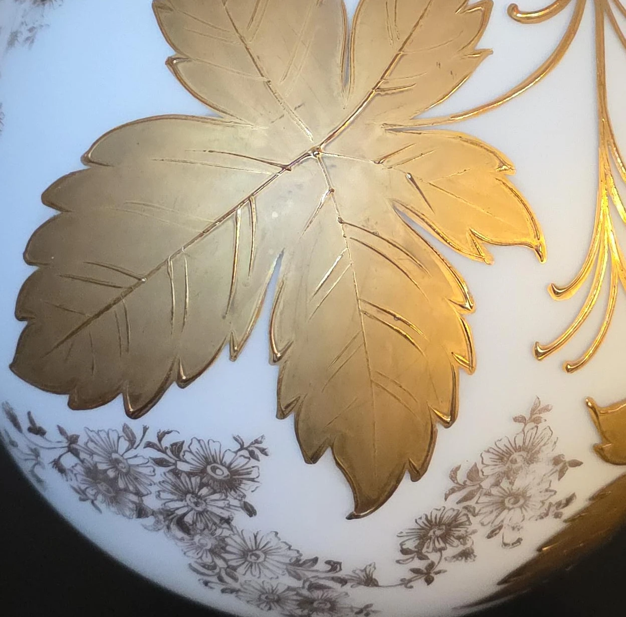 White globe light fixture with gold leaf and floral accents