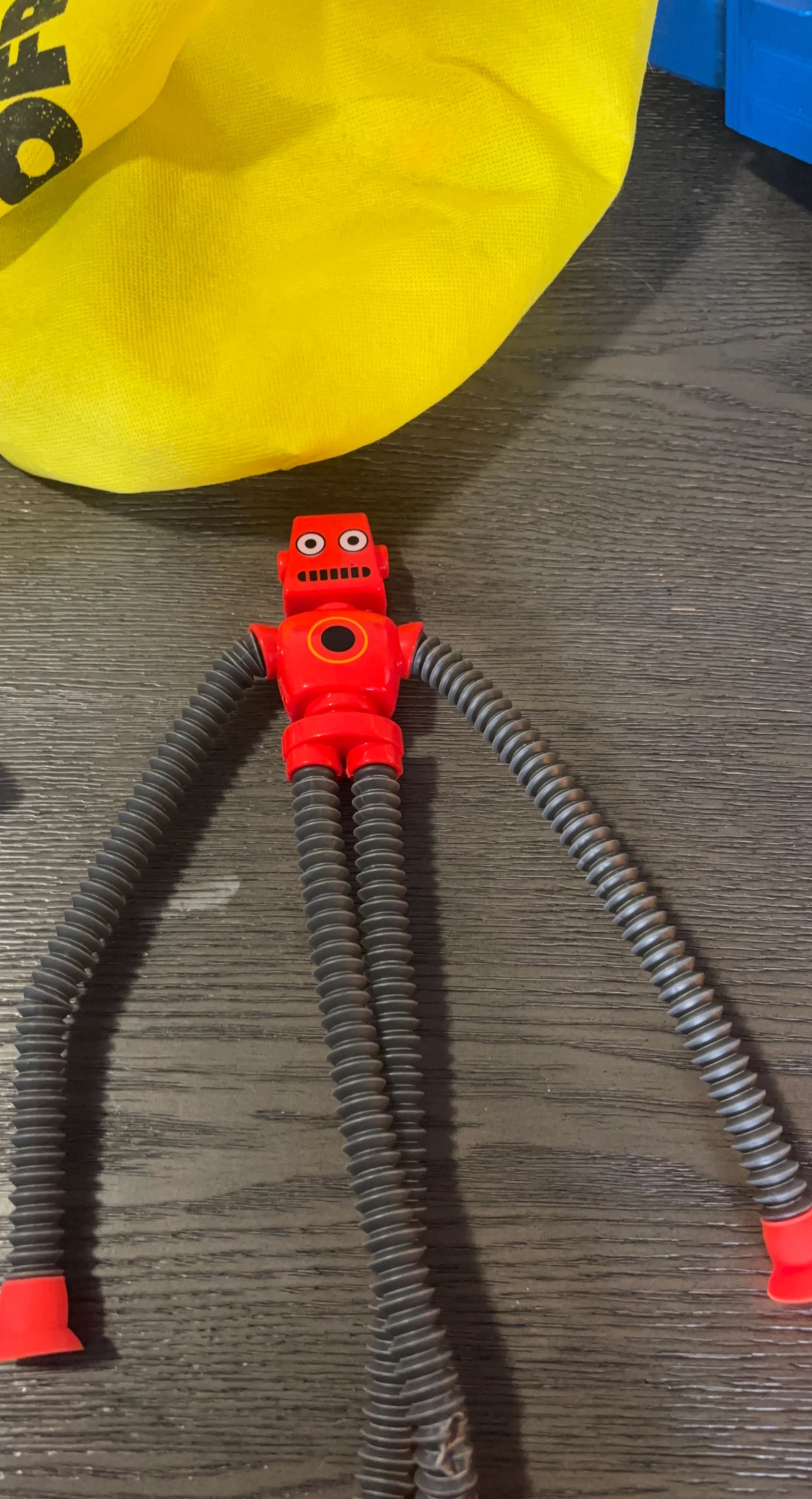 Red Bendy Robot Toy with Yellow Bag