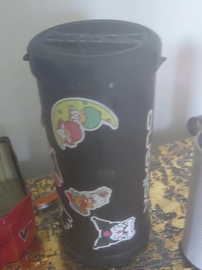Black cylindrical speaker with stickers