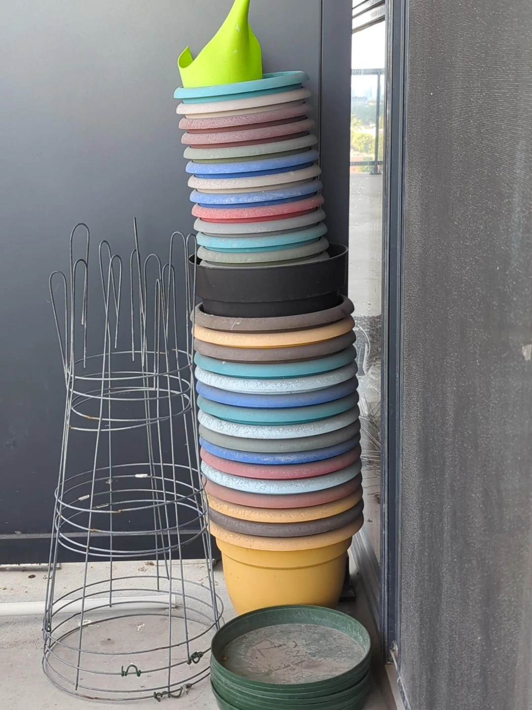 Stack of Assorted Plastic Plant Pots and Trellis for tomatoes