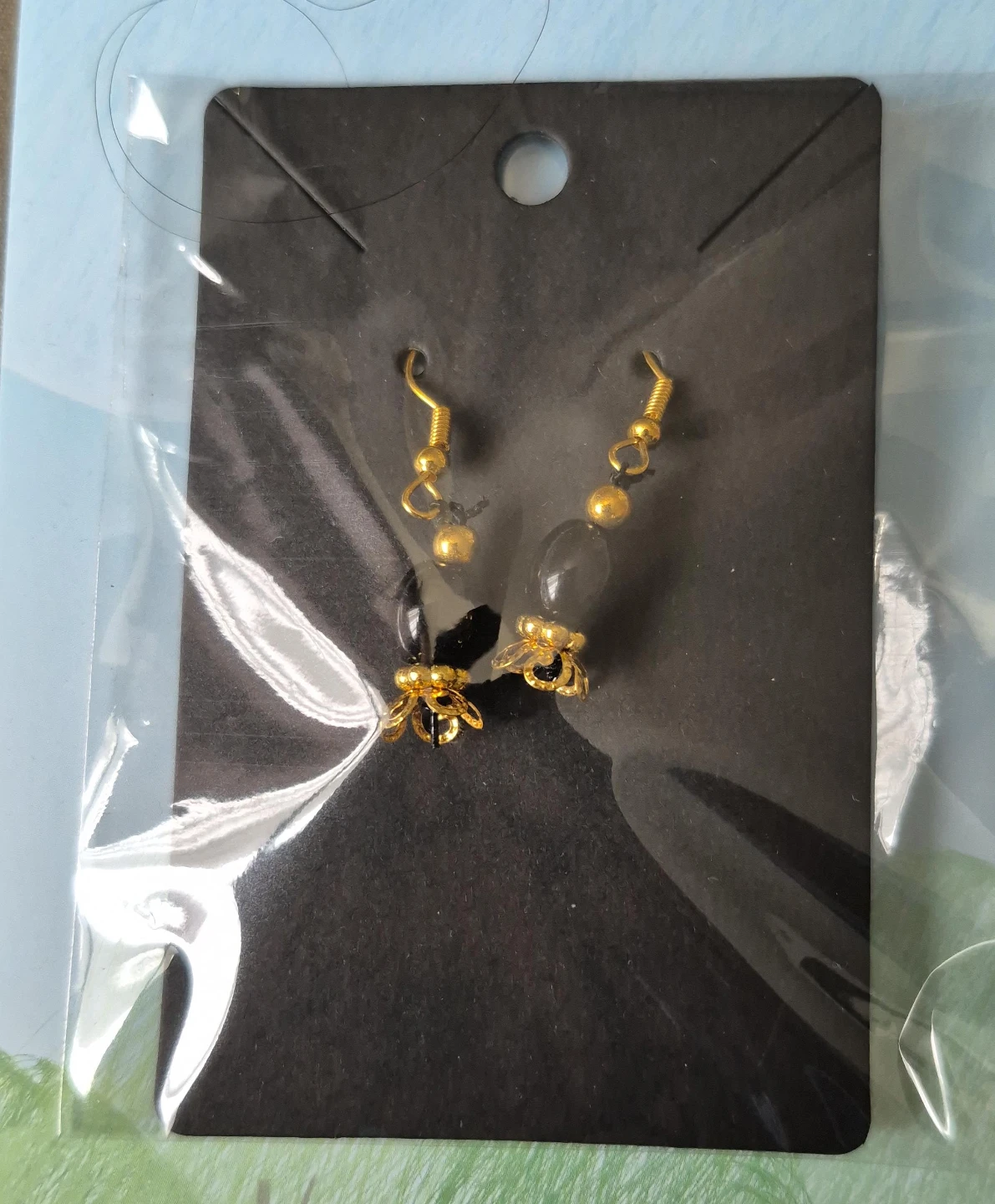Gold tone beaded earrings with black and clear stones