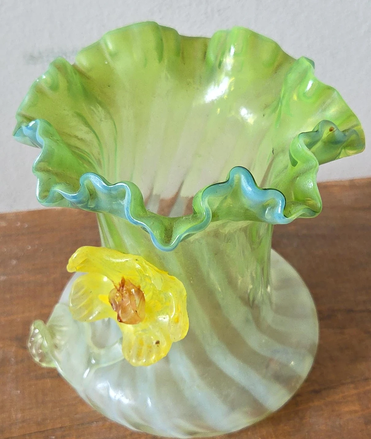 Green glass vase with yellow flower accent