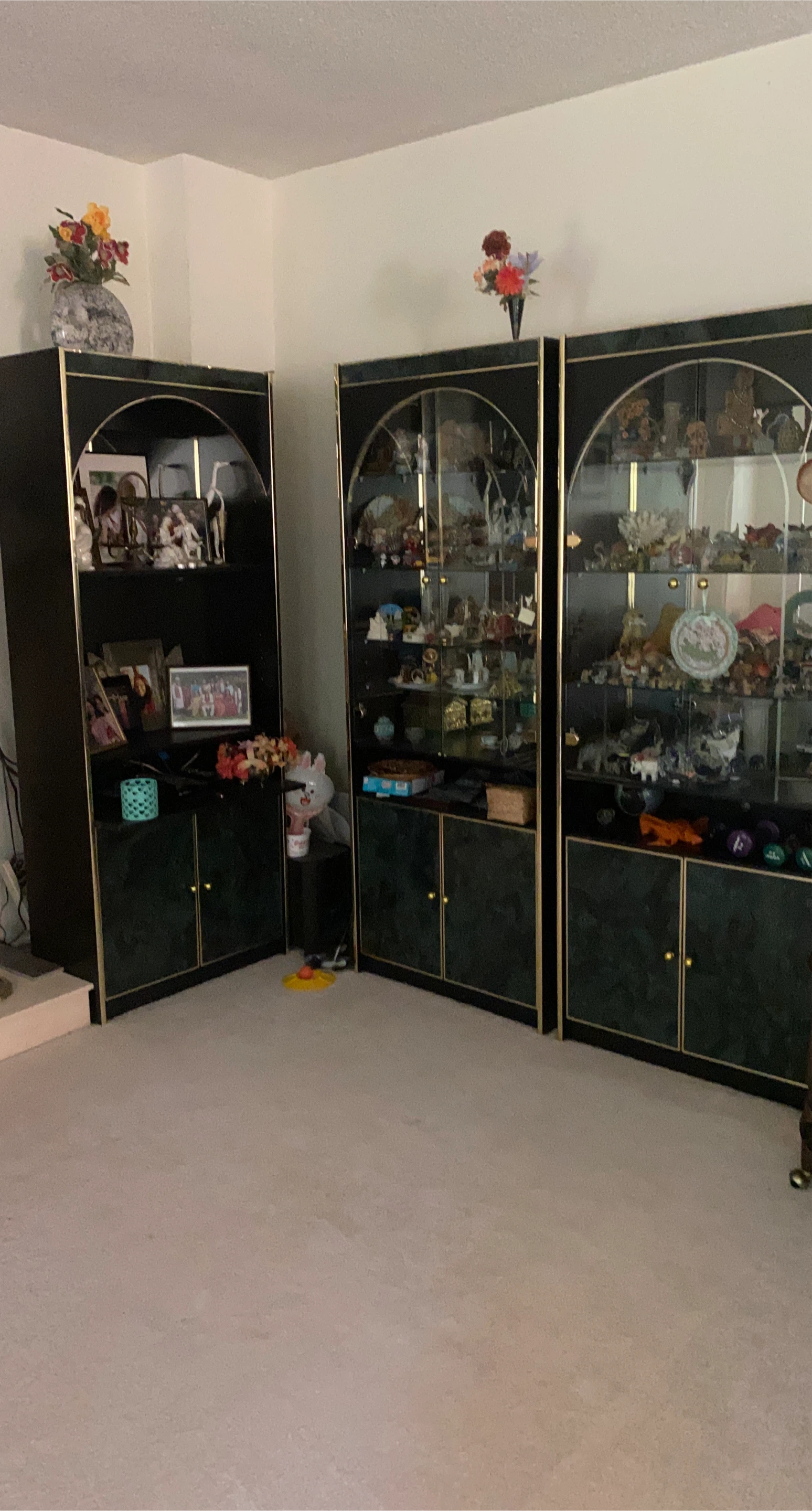 Three piece black and gold curio cabinets