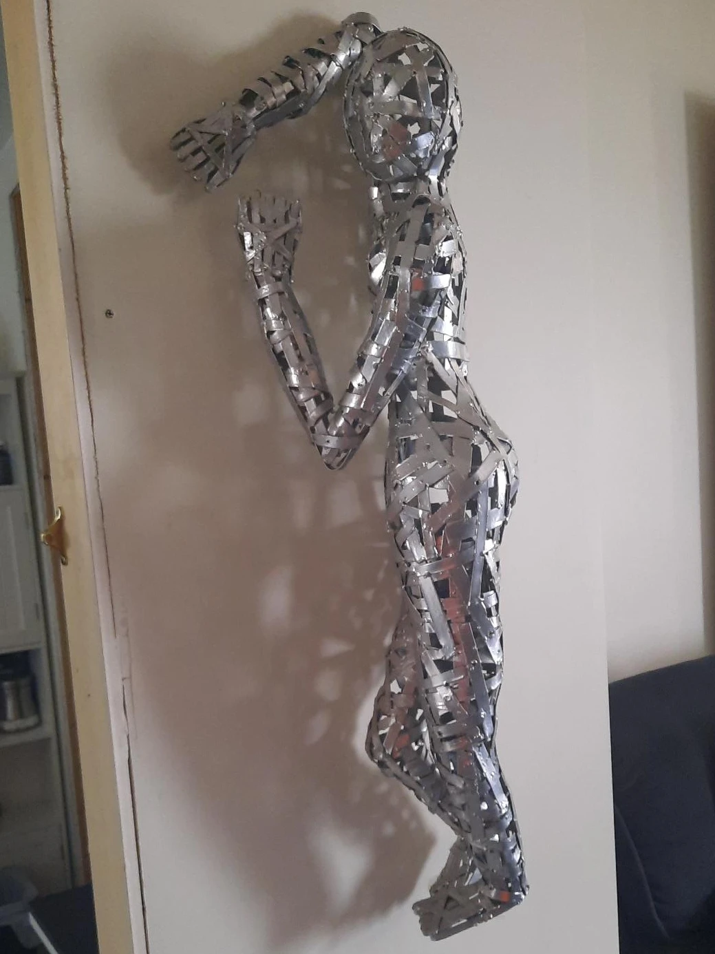 Sculpture of a person made from silver metal strips