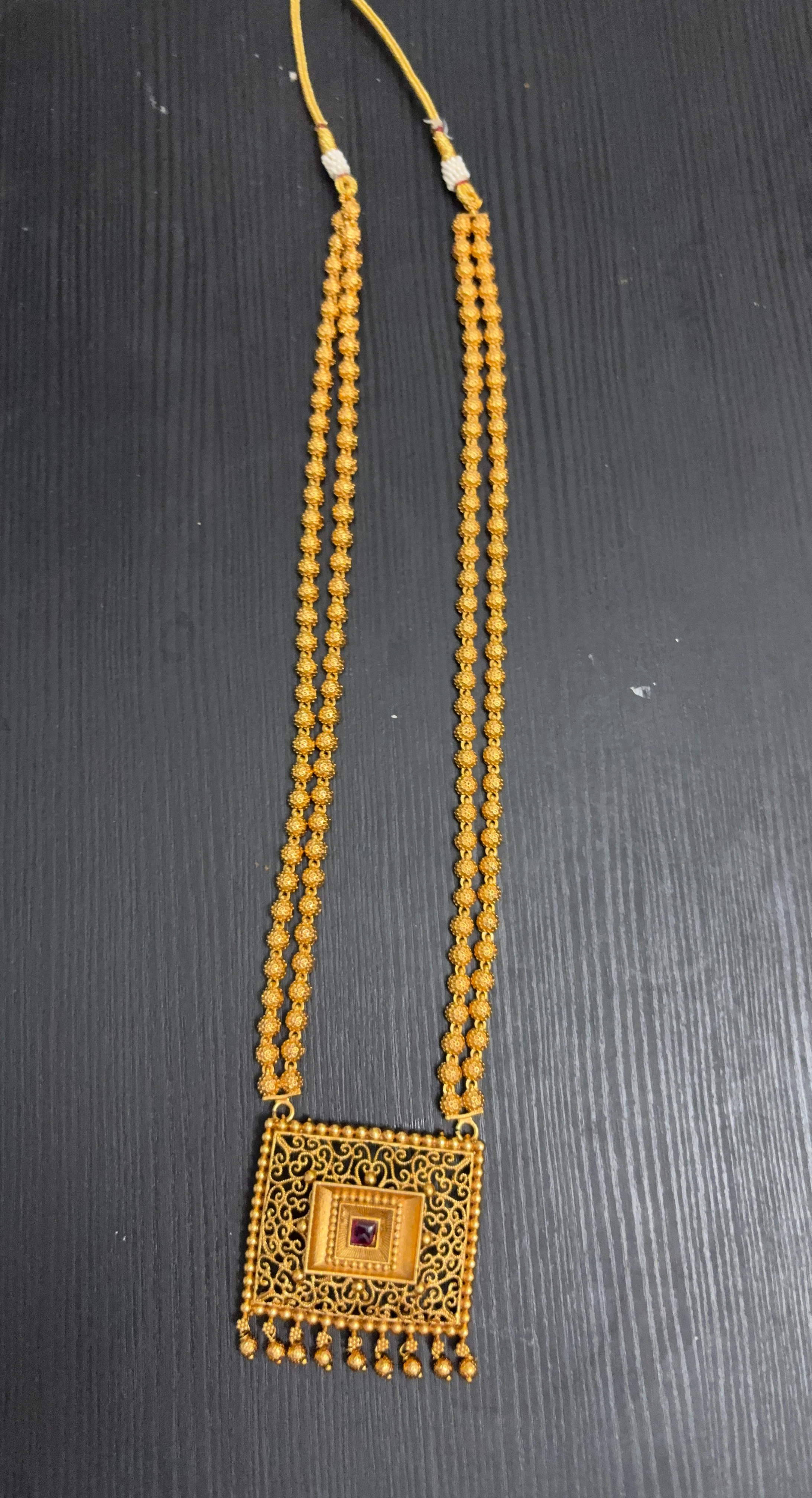 Gold-tone double strand necklace with ornate pendant
