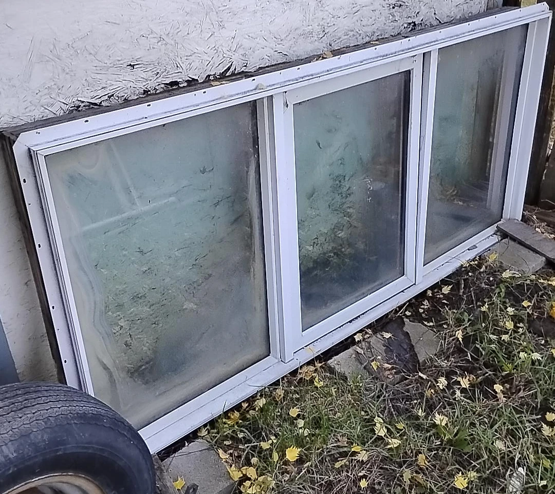 Three-pane white vinyl sliding window