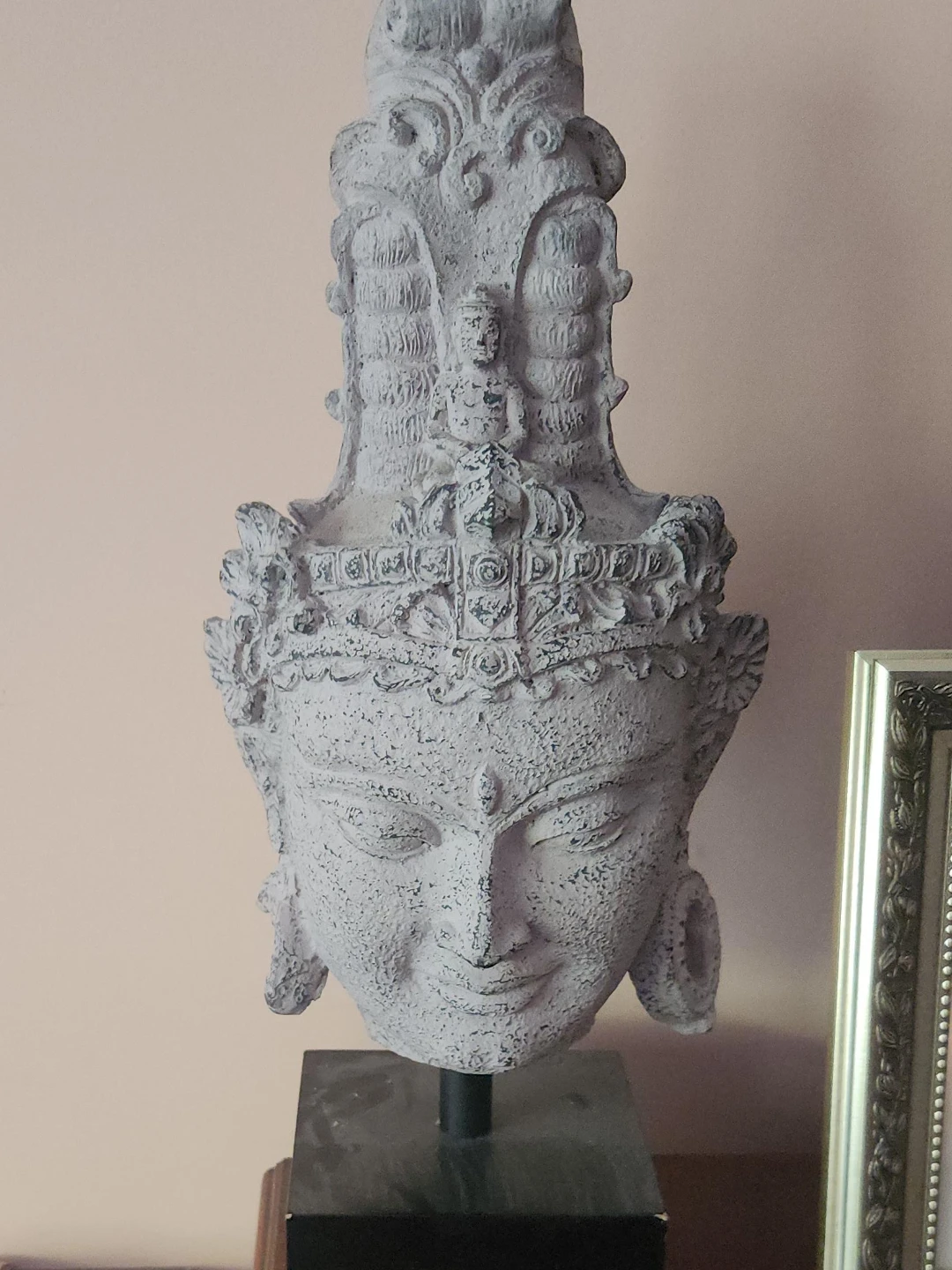 Balinese style stone statue on wooden stand