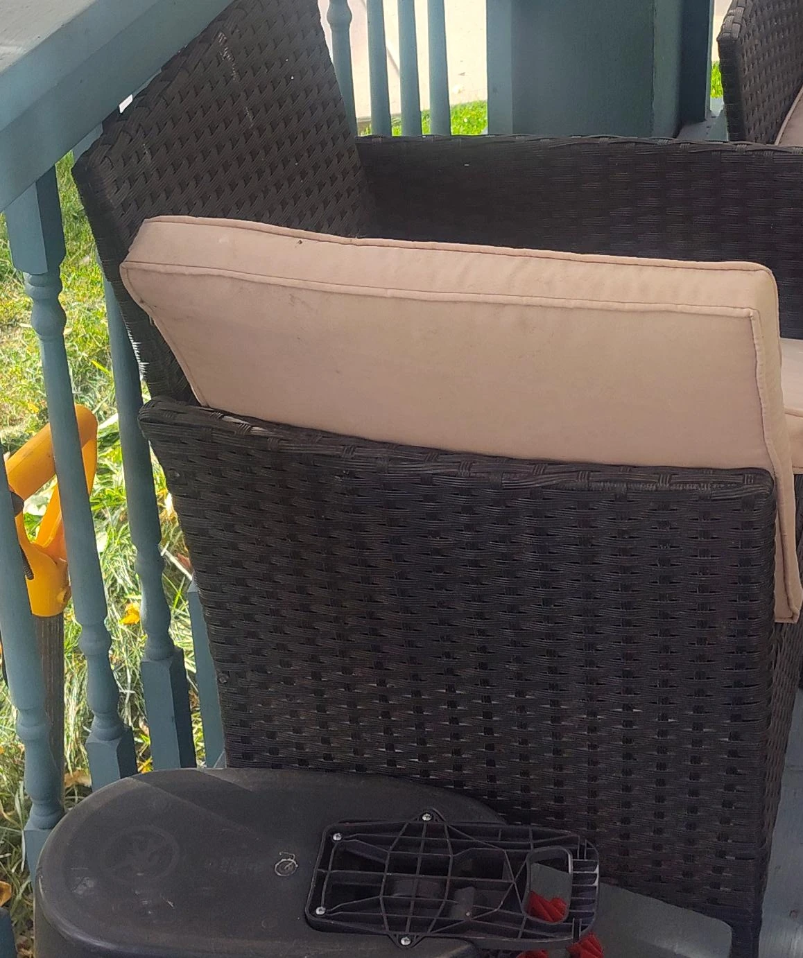 Dark brown wicker patio chair with beige cushion