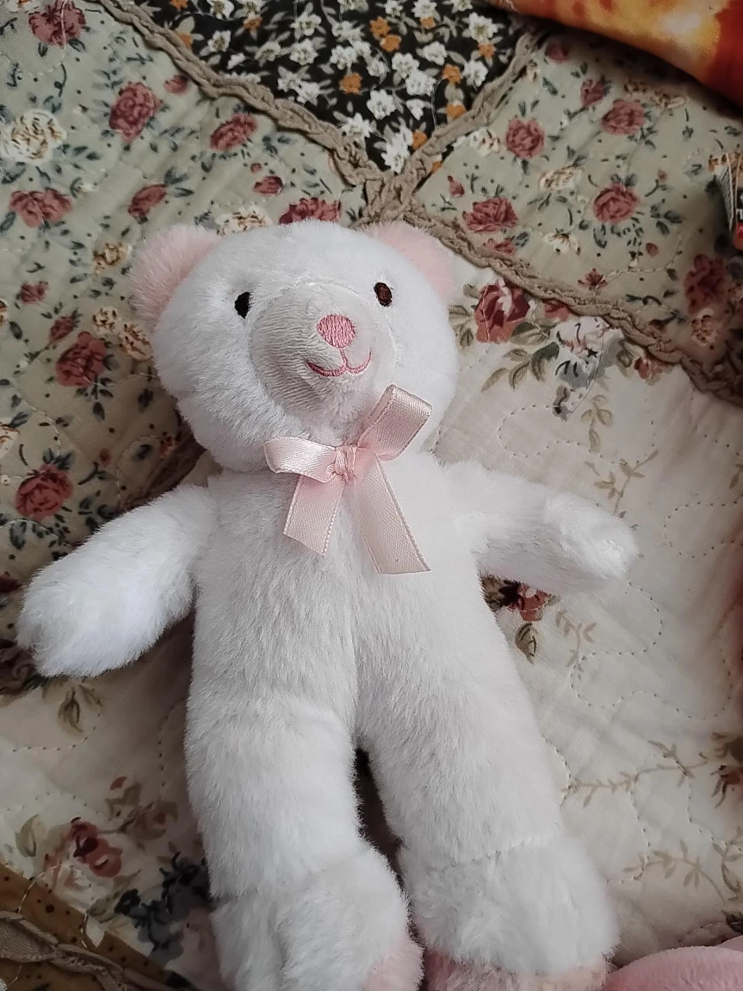 White plush teddy bear with pink bow